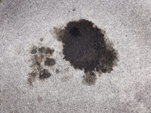 close up of oil stain on asphalt driveway